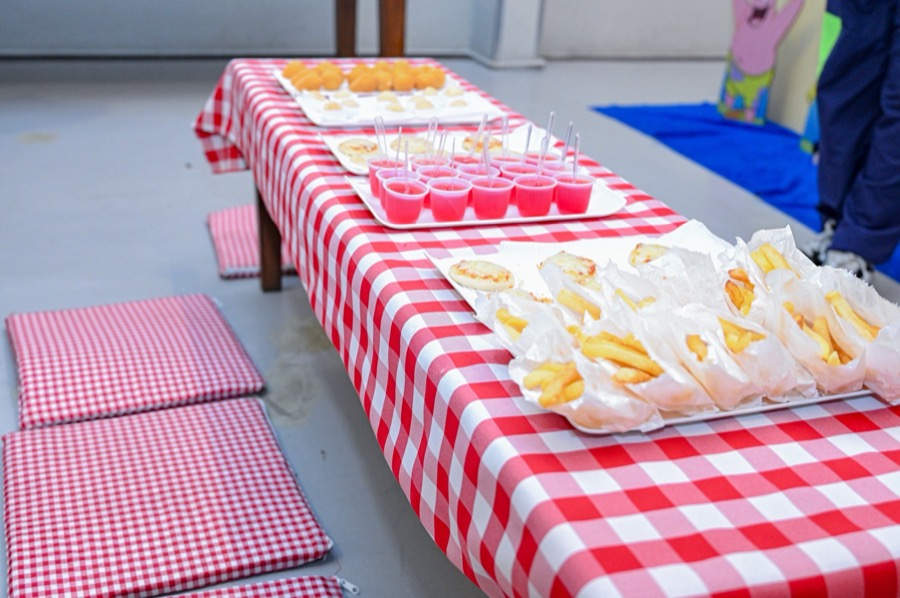 Mesa de piquenique com salgados, batatas e sucos
